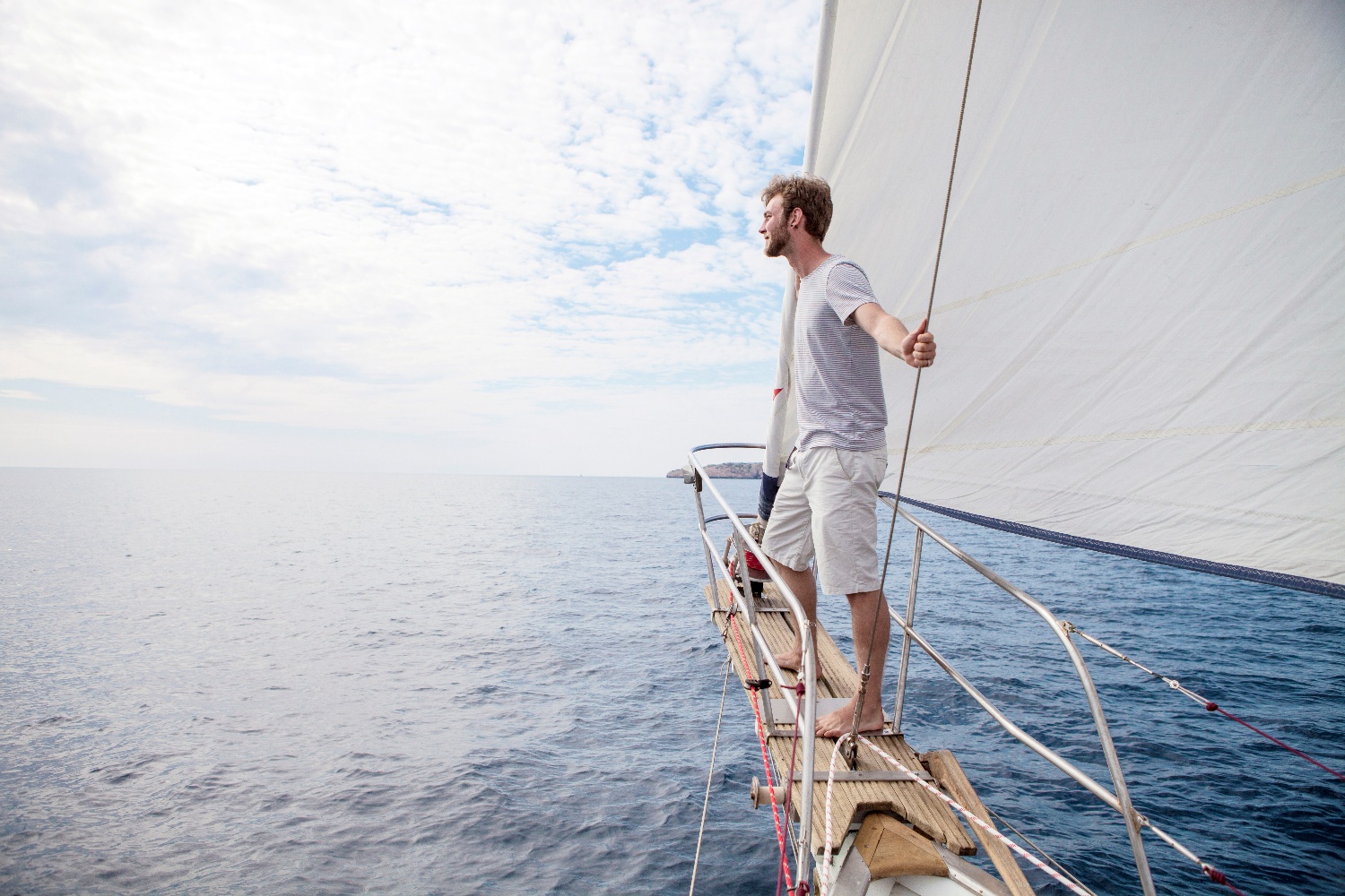 Mann in Segelboot auf offenem Meer